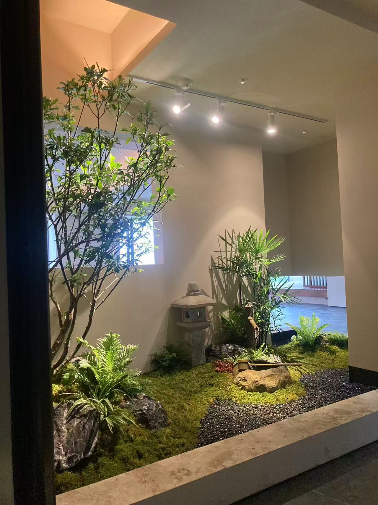 自然砂岩水缽旁細水聲與深色碎石小徑呈現沉穩的室內庭園氛圍